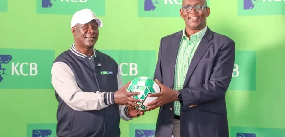 Two men exchanging a soccer ball at KCB event