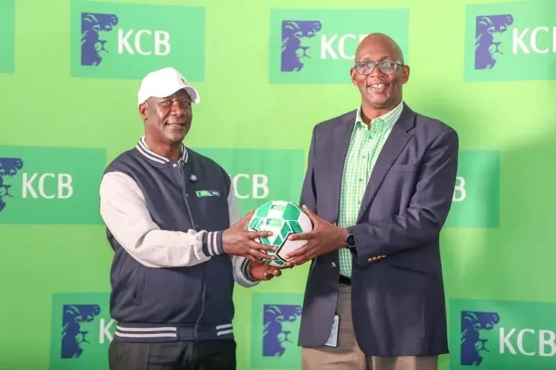 Two men exchanging a soccer ball at KCB event