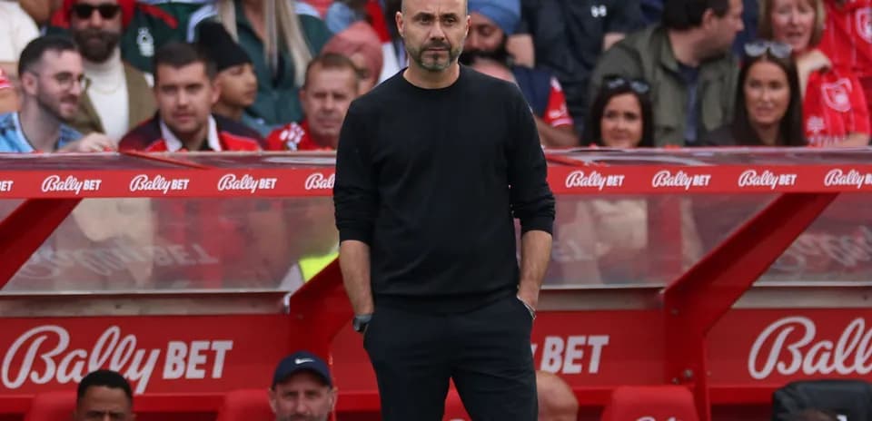 Coach observing game from sideline bench