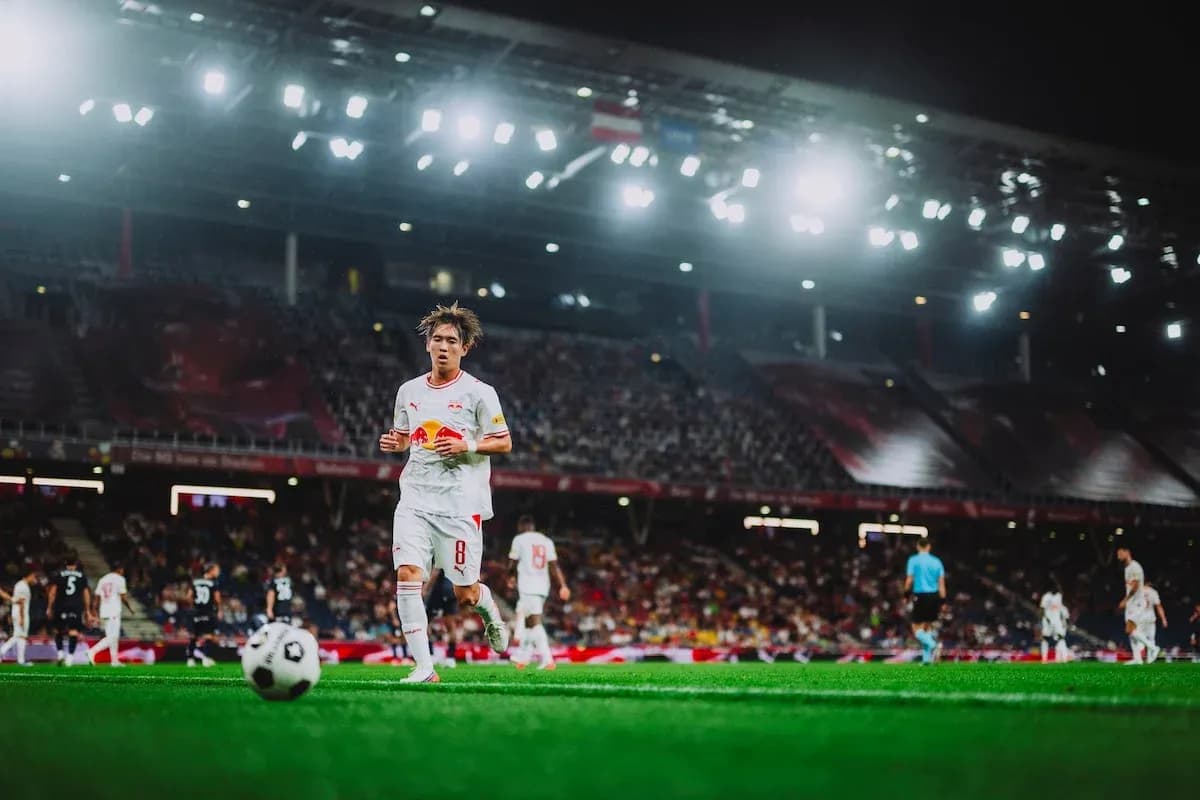 Futbol matçında topu qovlayan oyunçu