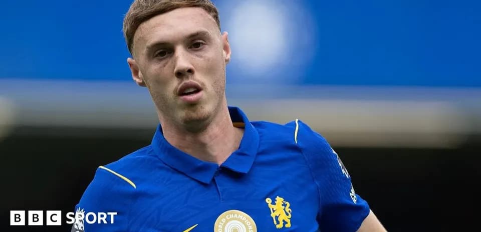 Futbolçu mavi forma ilə oyun sahasında