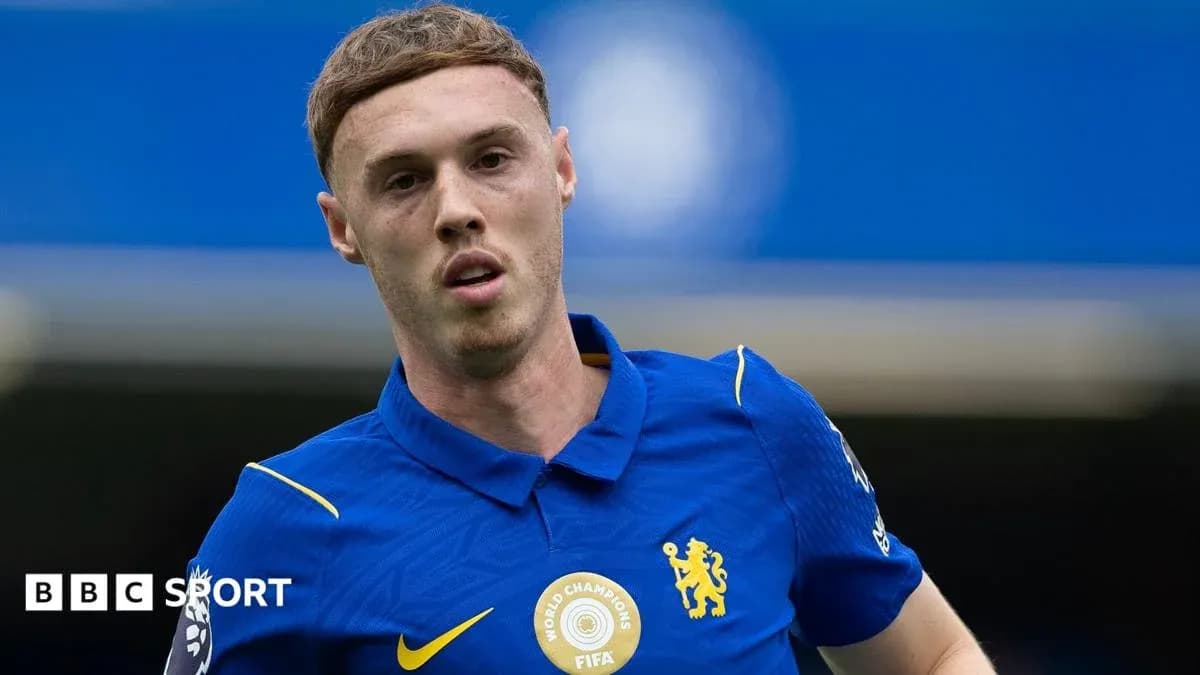 Futbolçu mavi forma ilə oyun sahasında