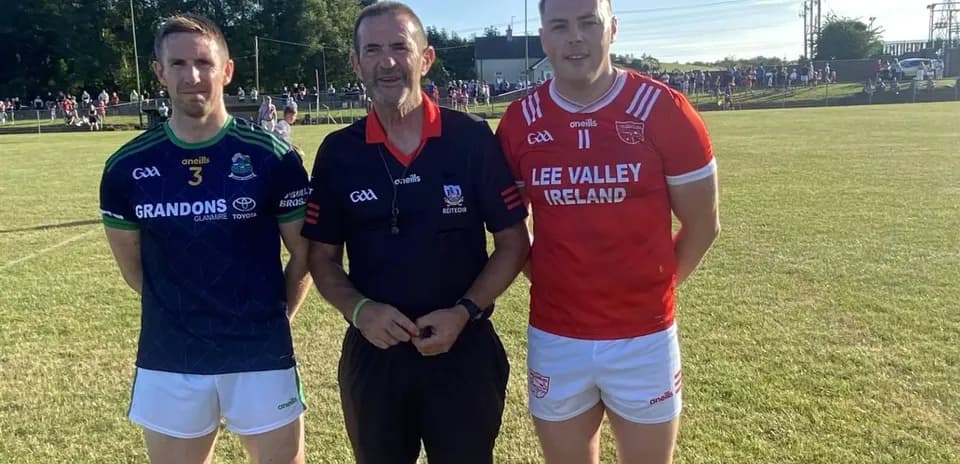 Two players and referee posing on field