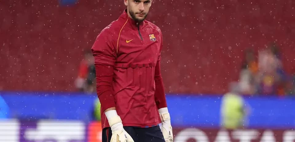 Goalkeeper in training kit at stadium during rain