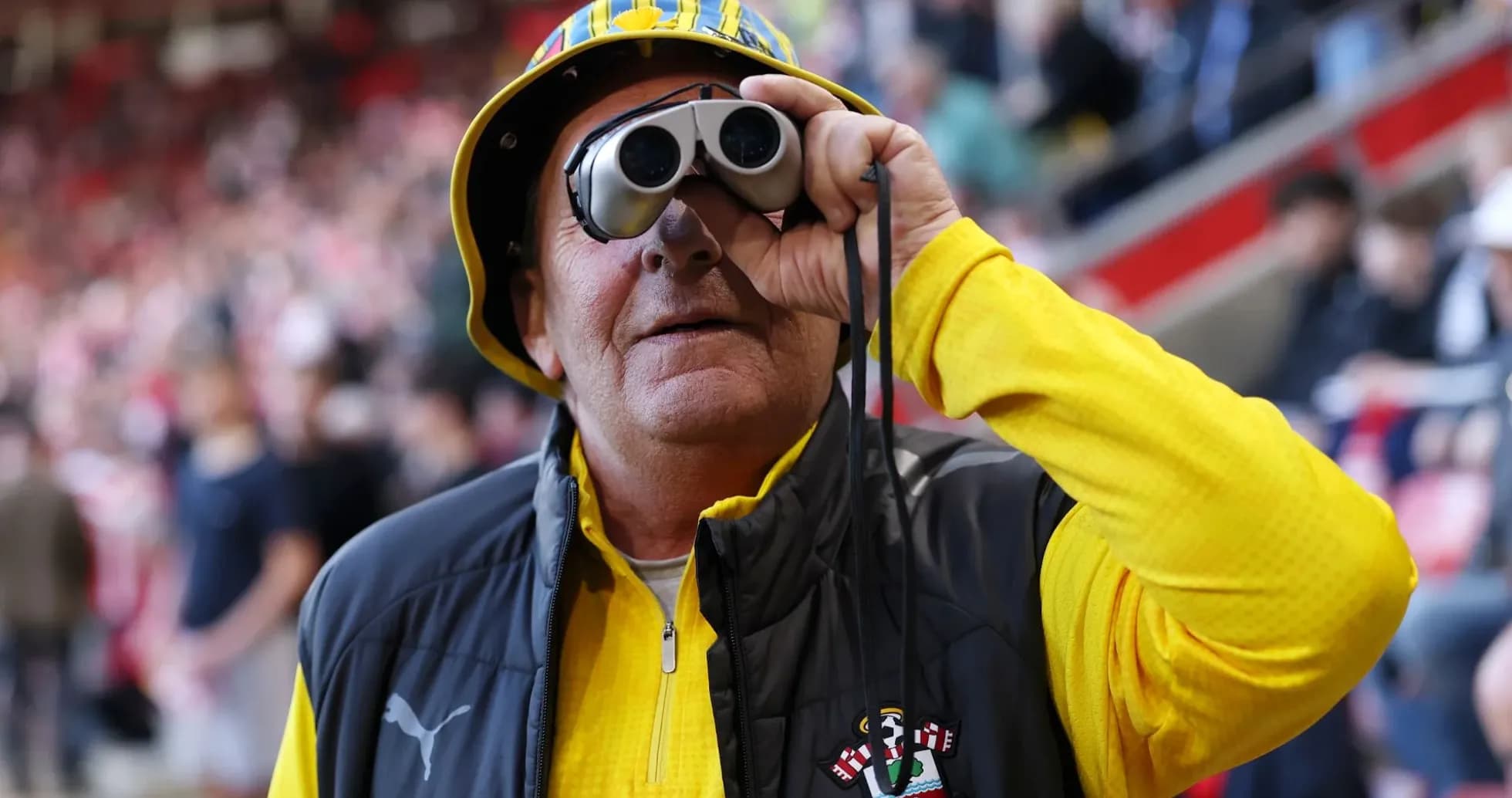Fan with binoculars wearing Southampton FC attire