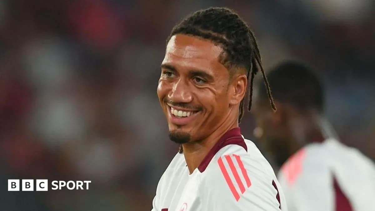 Futbolçu gülərək oyun sahəsində durur