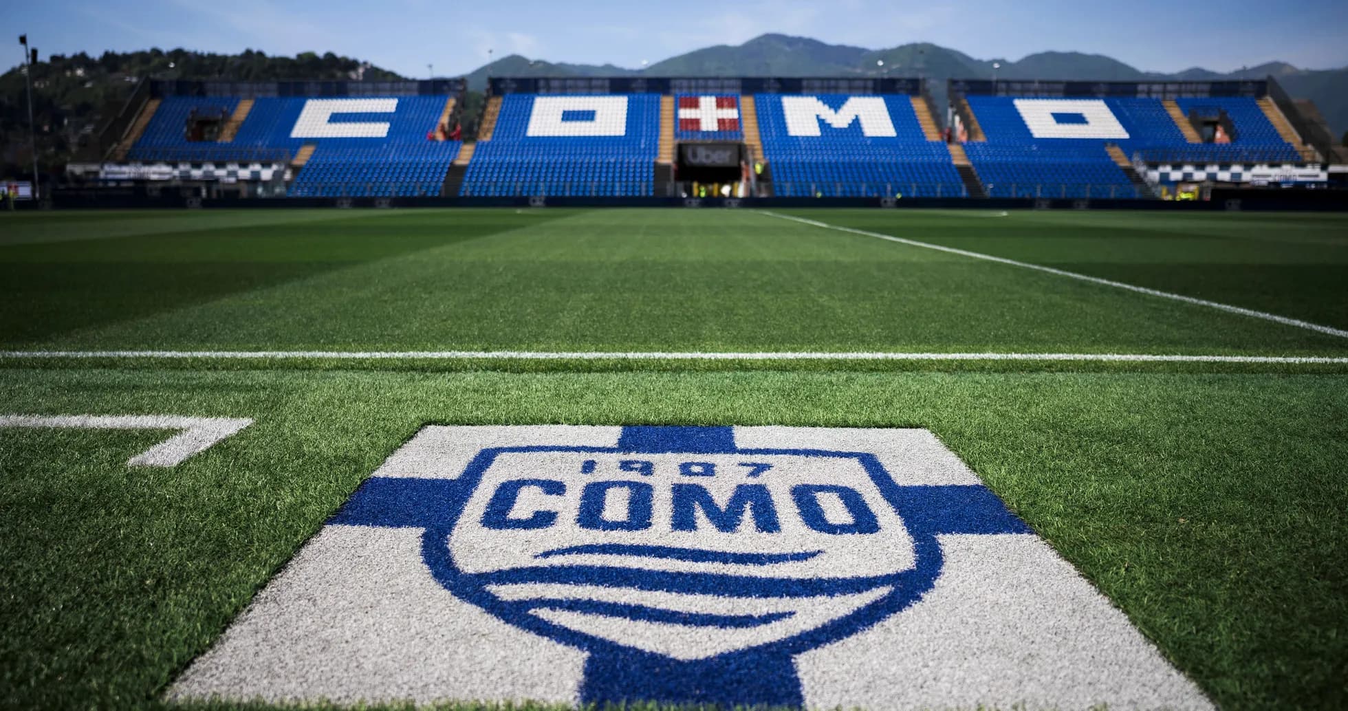 Stadium field with Como logo and seats in background