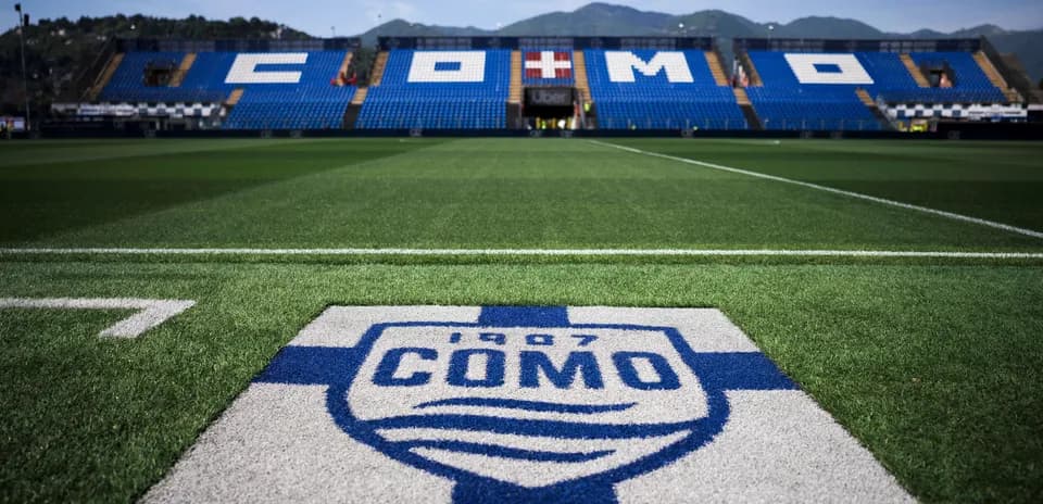 Stadium field with Como logo and seats in background