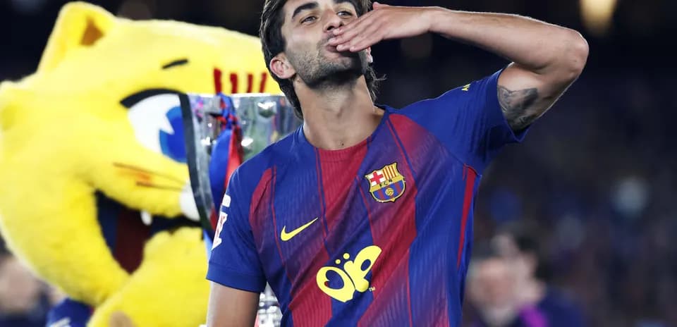Barcelona player celebrating with trophy and mascot