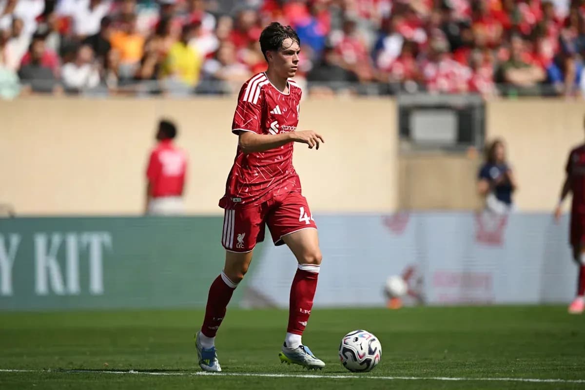 Futbolçu topu idarə edir, stadionda oyun keçirilir