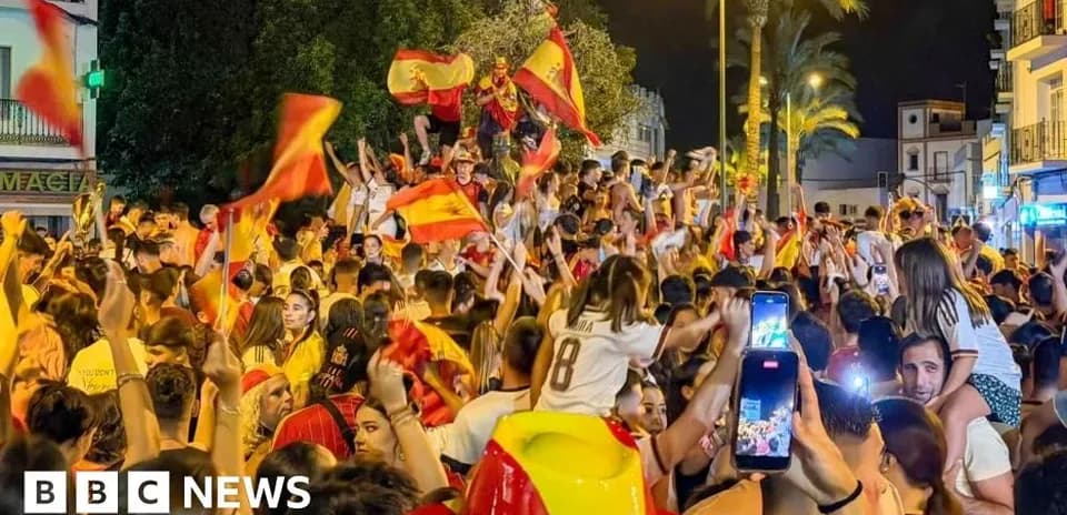 Fans celebrating with flags in lively street crowd