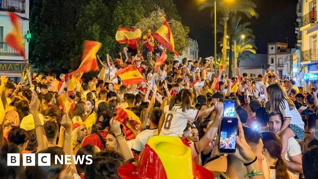 Fans celebrating with flags in lively street crowd