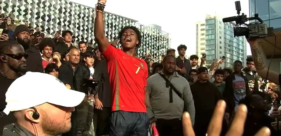 Fan celebrating in Portugal jersey with crowd behind