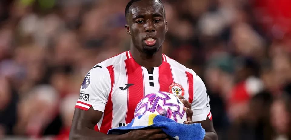 Brentford player holding ball and towel on pitch