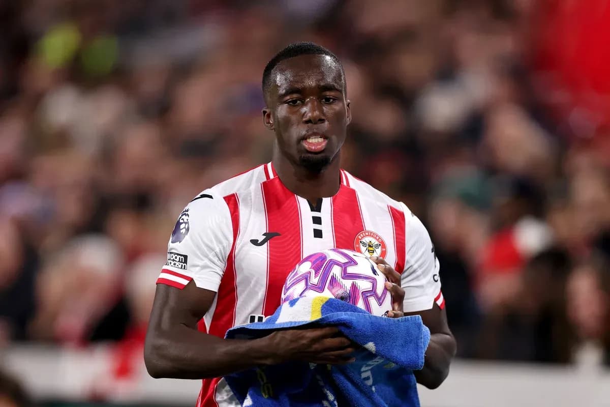 Brentford player holding ball and towel on pitch