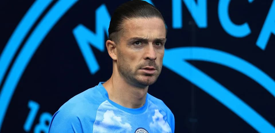 Futbolçu mavi köynəkdə kameraya baxır