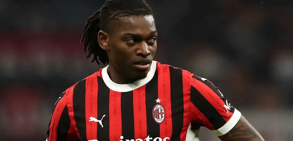 AC Milan player in red and black jersey on field