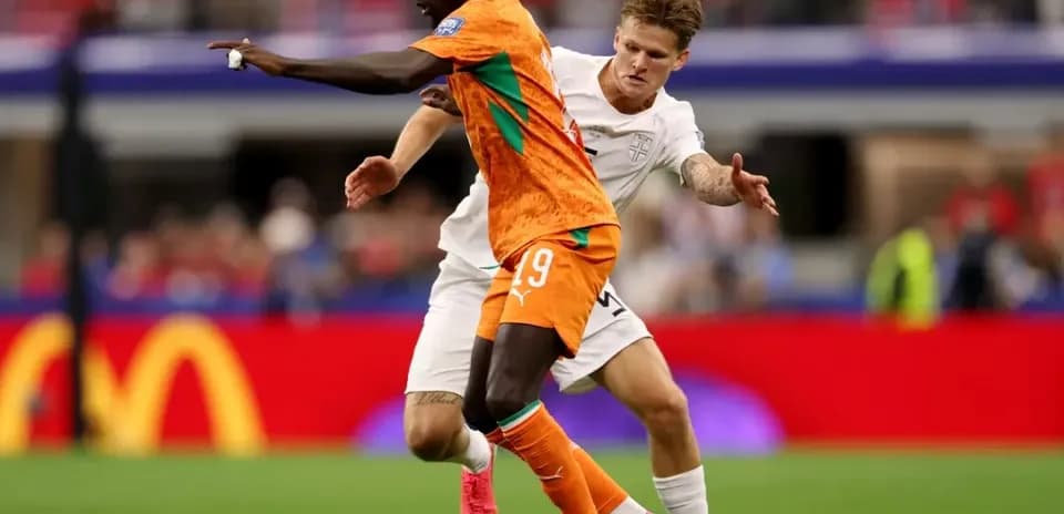 Player in orange jersey evading opponent in white