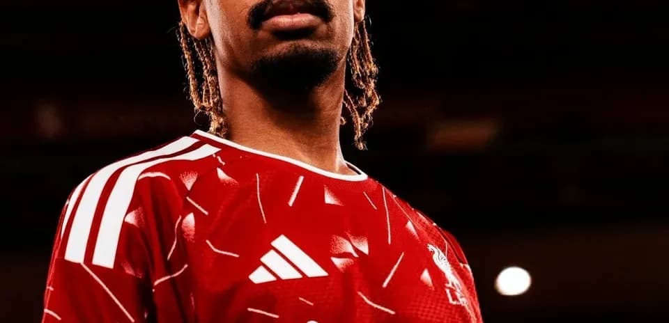 Futbolçu qırmızı forma ilə poz verərək durur