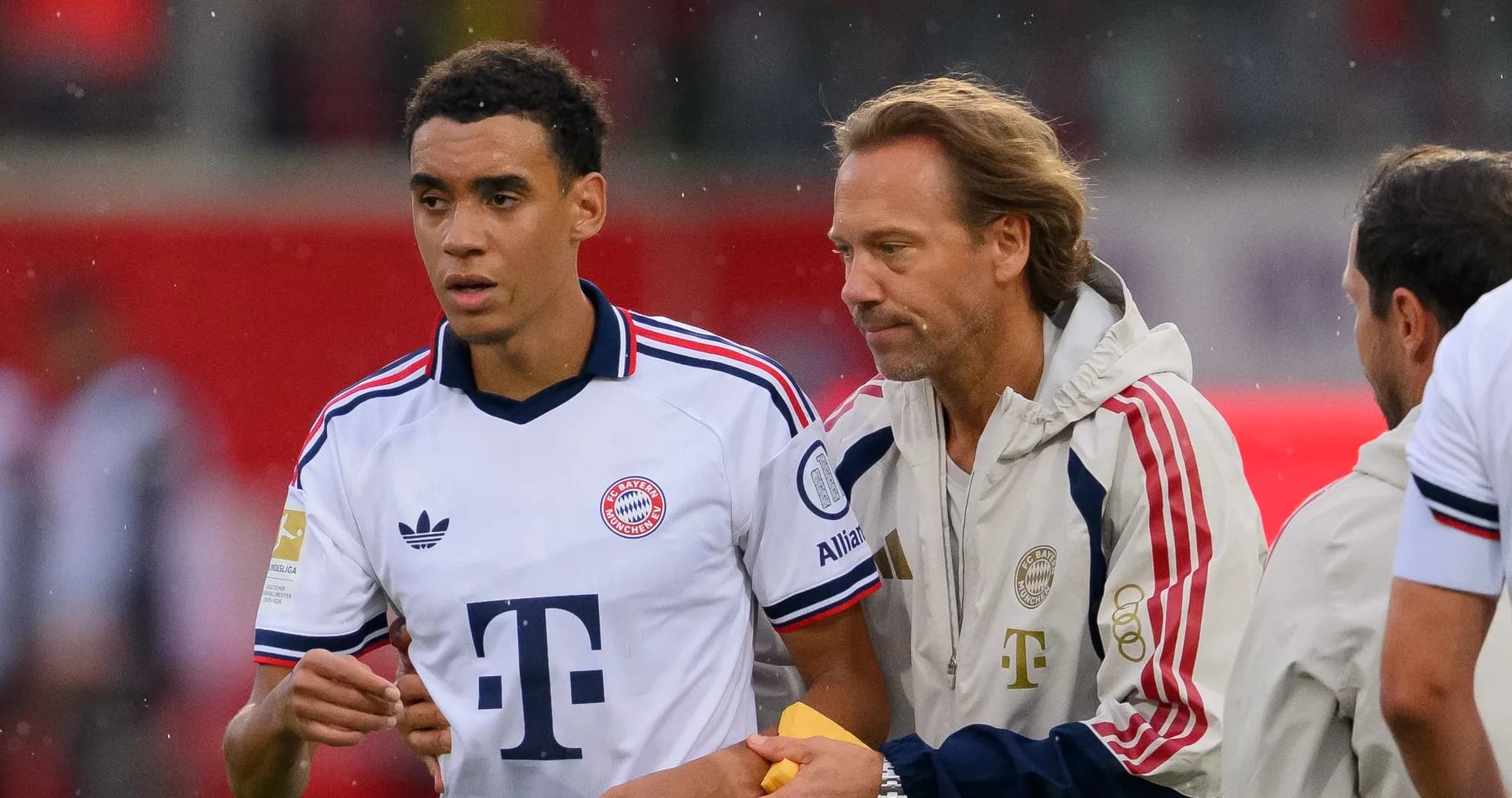 Bayern Munich player and coach discussing on sideline