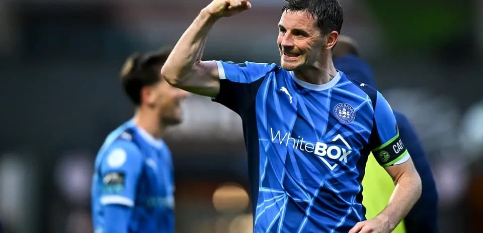 Futbolçu sevinclə əllərini qaldırır