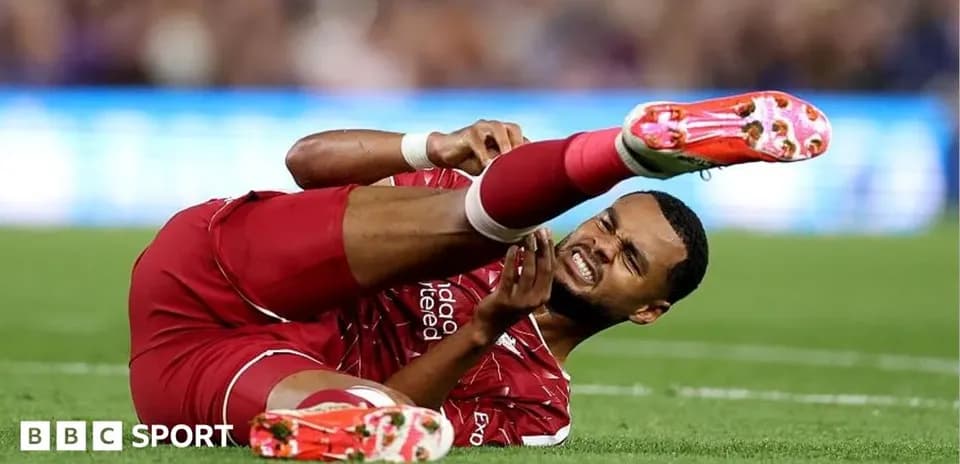 Player in red kit lying injured on the field
