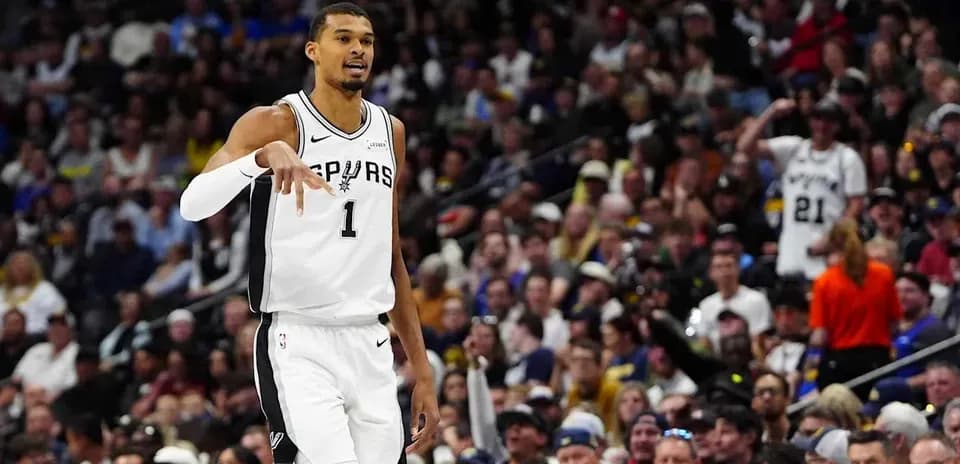Basketball player signaling during game with crowd behind