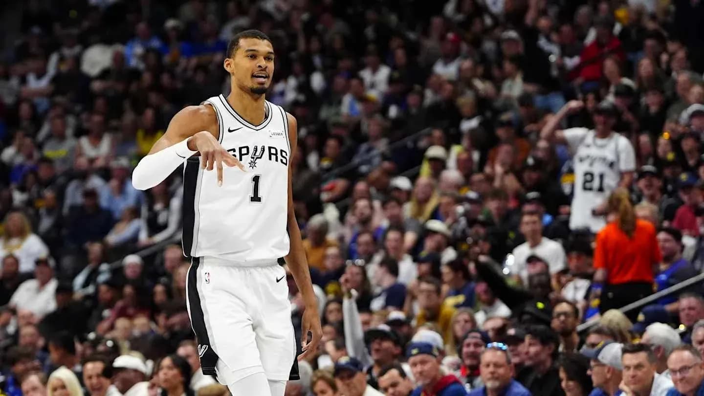 Basketball player signaling during game with crowd behind