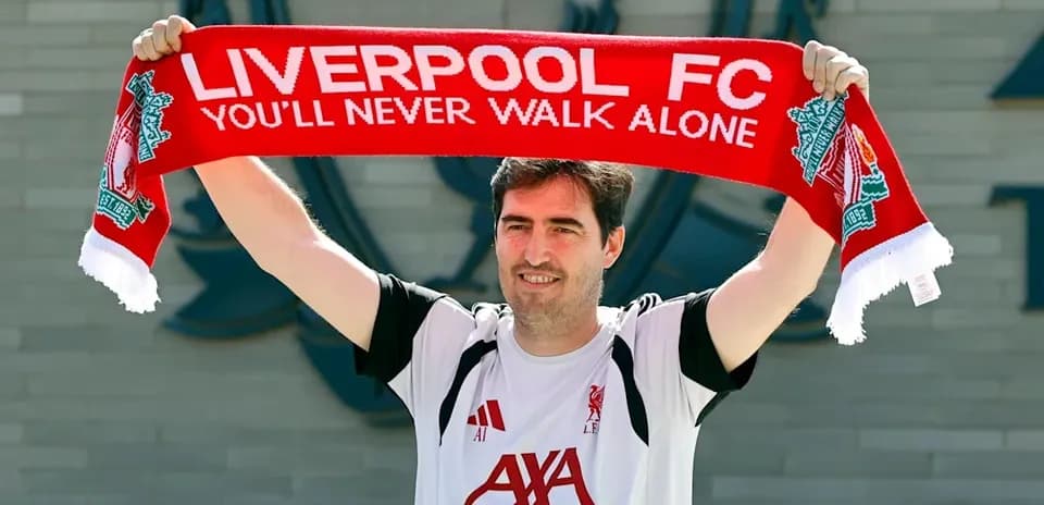 New player holding Liverpool FC scarf at club