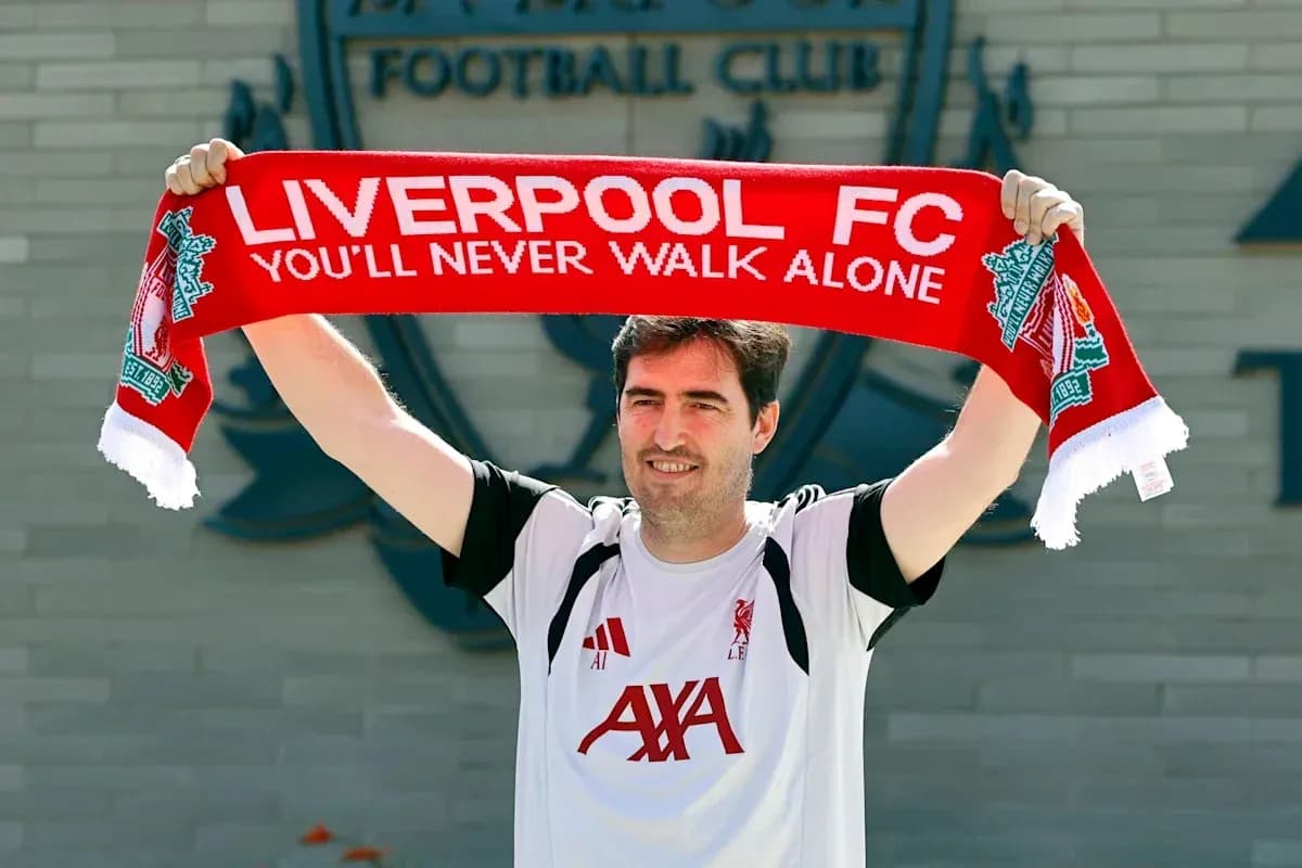 New player holding Liverpool FC scarf at club