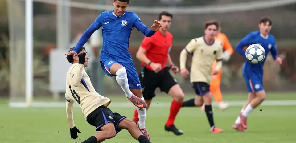 Player from Chelsea jumping over opponent on field