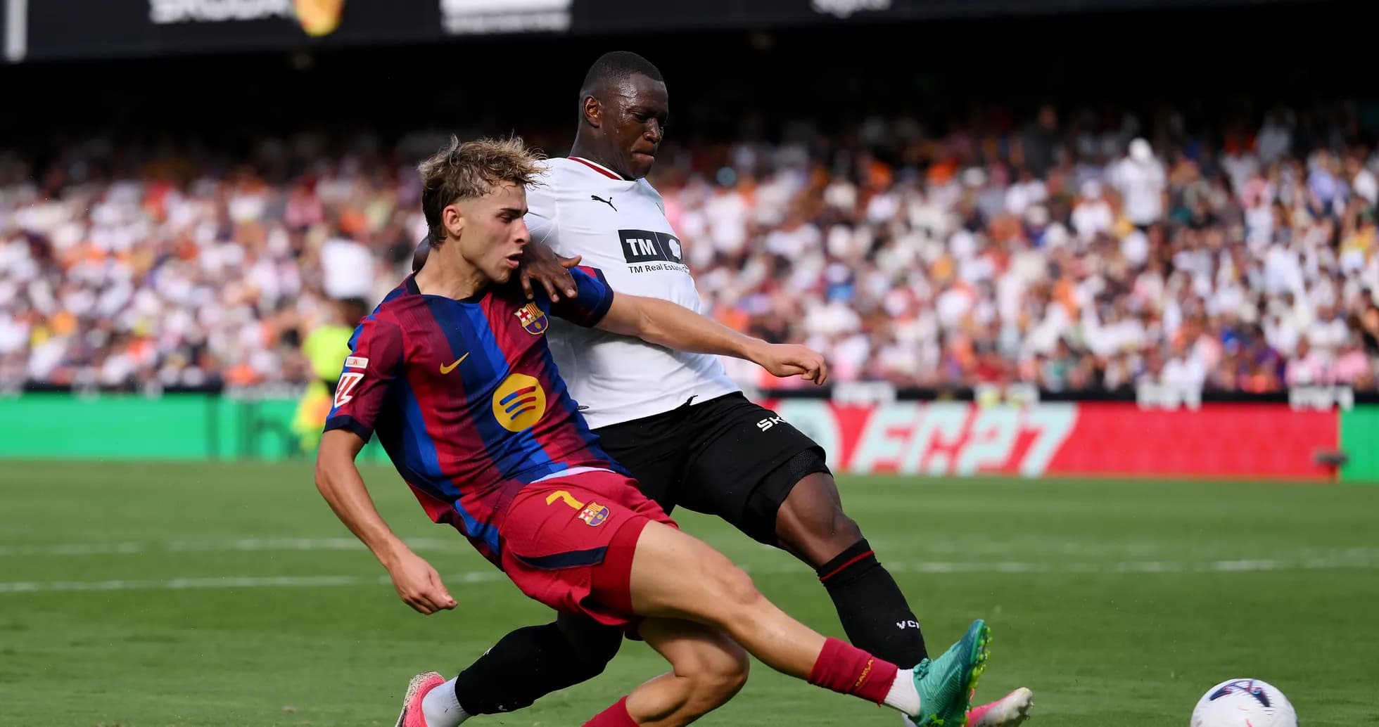 Barcelona player challenging opponent for the ball