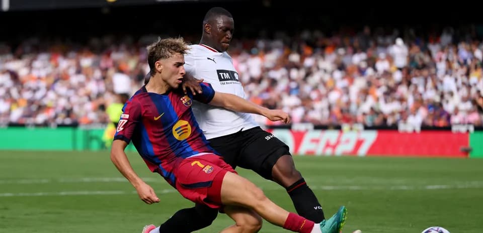 Barcelona player challenging opponent for the ball