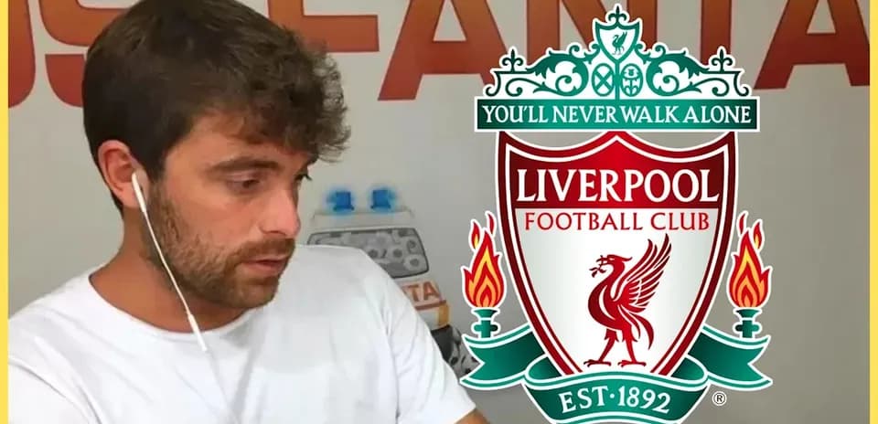 Man listening with earphones near Liverpool FC logo