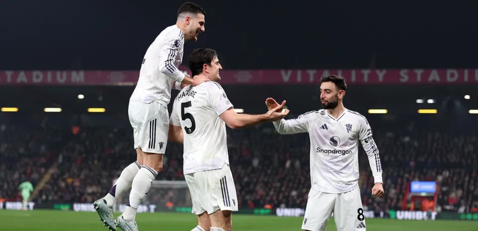 Three players celebrating a goal at stadium