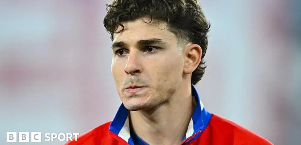Futbolçu mavi və qırmızı formada durur