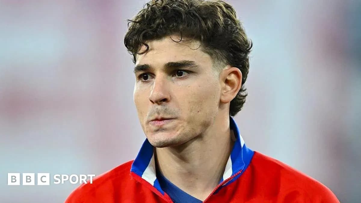 Futbolçu mavi və qırmızı formada durur