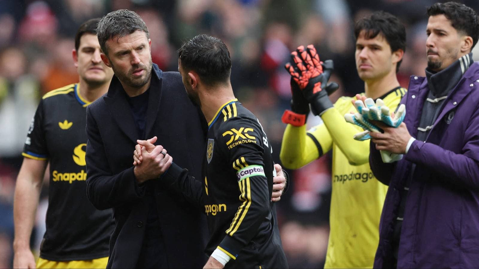 Coach and player shaking hands on the pitch