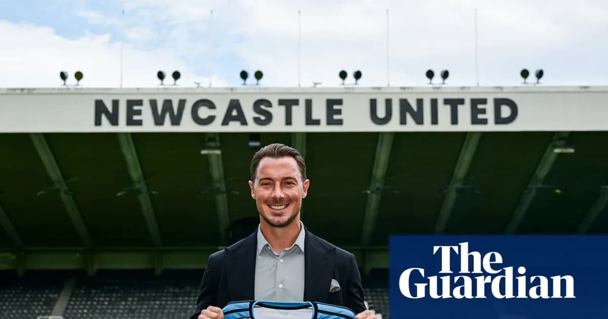 Newcastle United player holding team jersey at stadium