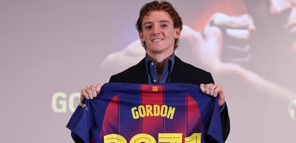 New player holding FC Barcelona jersey at presentation