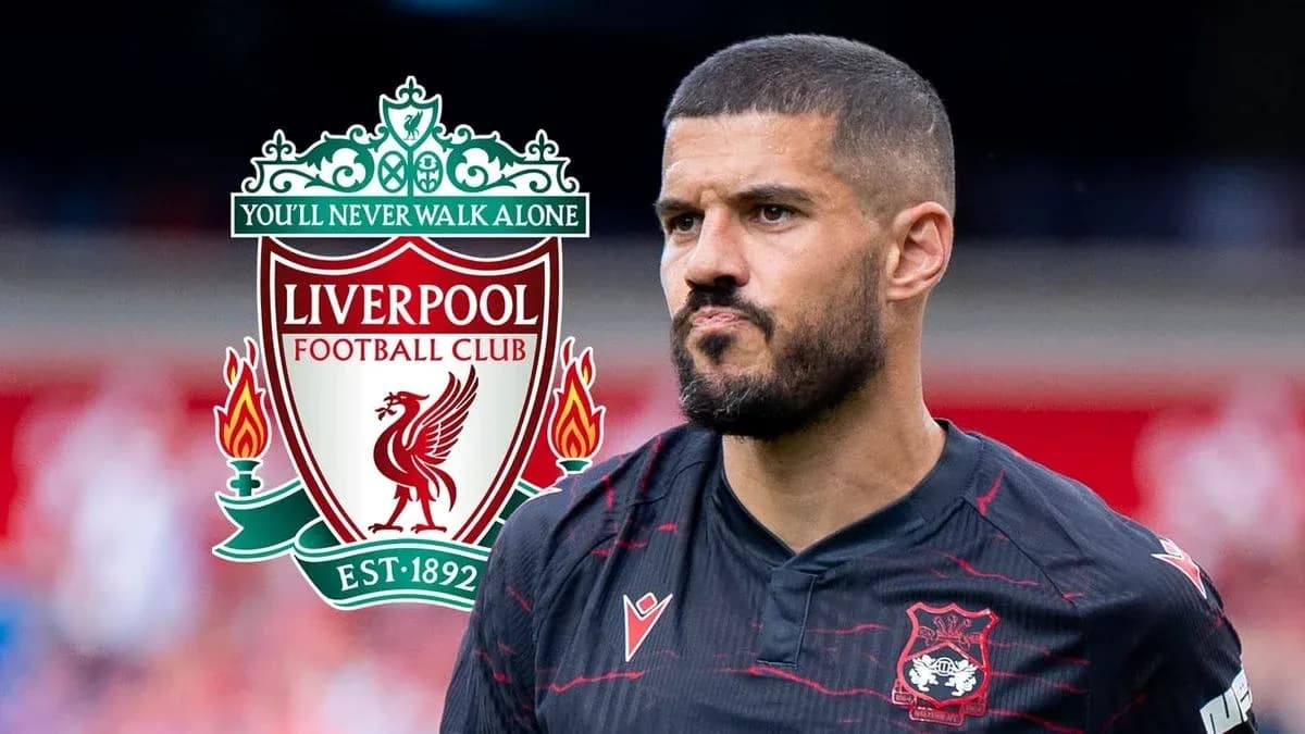 Futbolçu Liverpool logosu ilə arxa planda durur