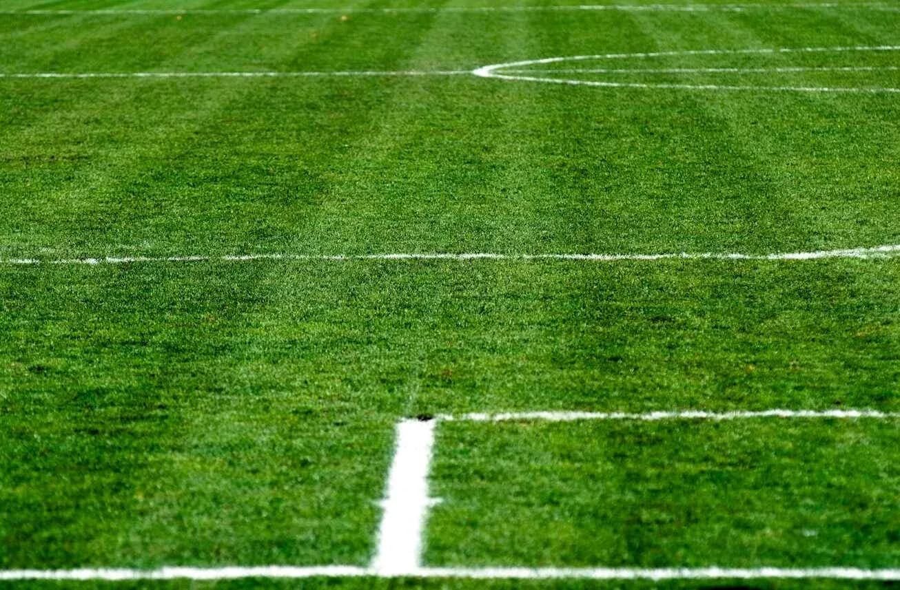 Yerdəki futbol sahəsinin yaşıllığı və xətləri