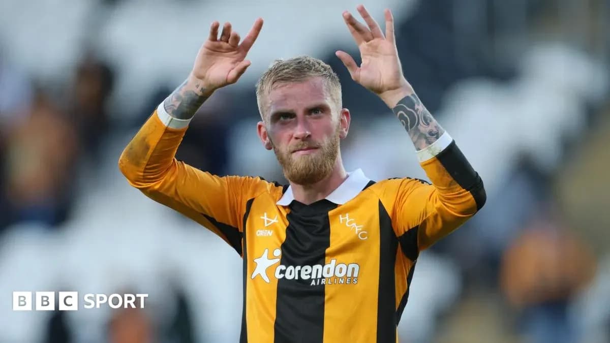 Futbolçu əlini qaldıraraq azarkeşləri salamlamaqdədir