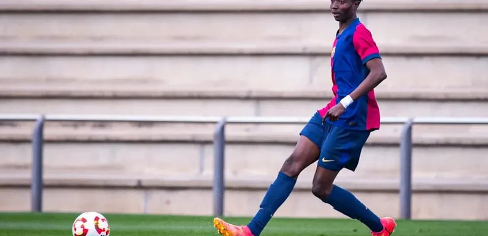 Player in Barcelona kit controlling ball on field