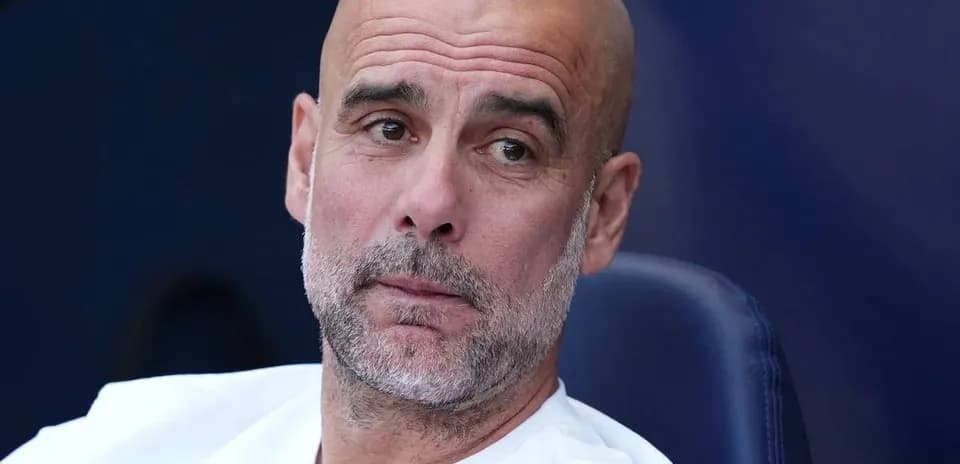 Football manager sitting on bench during match
