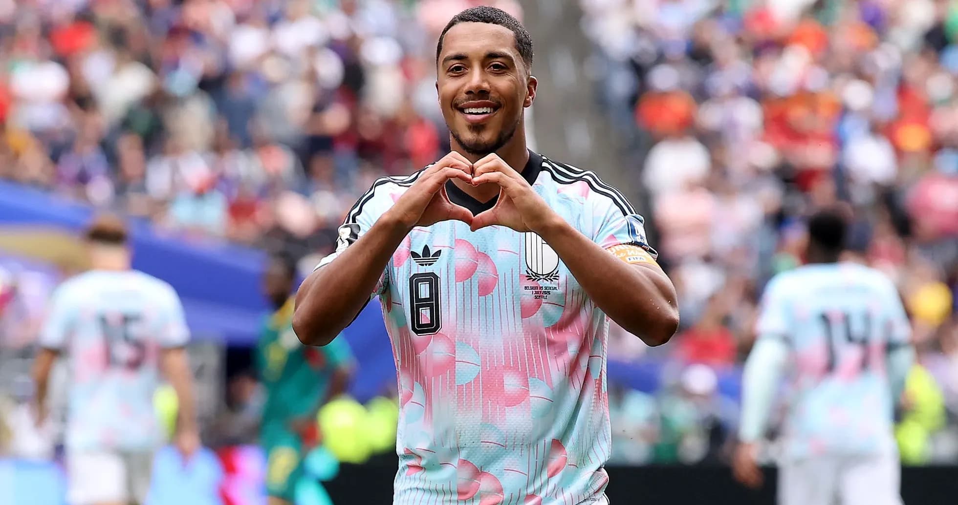 Player celebrating and making heart gesture on field