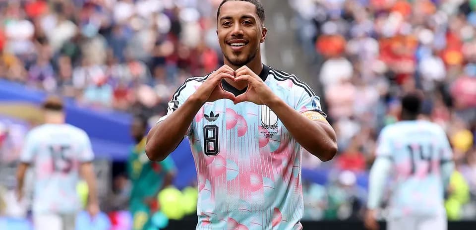 Player celebrating and making heart gesture on field