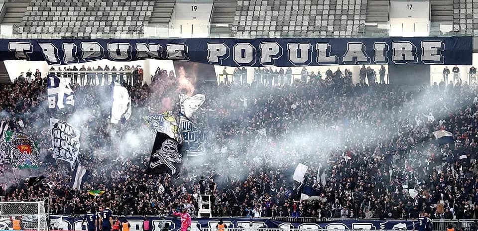 Fans cheering with banners and smoke in stadium