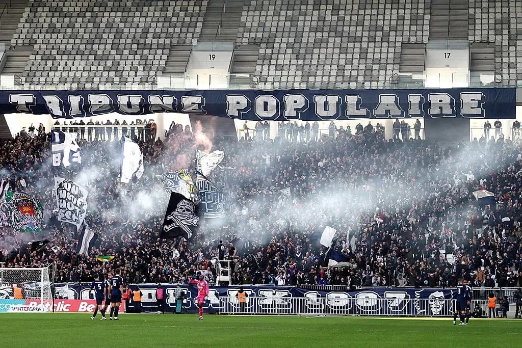 Fans cheering with banners and smoke in stadium