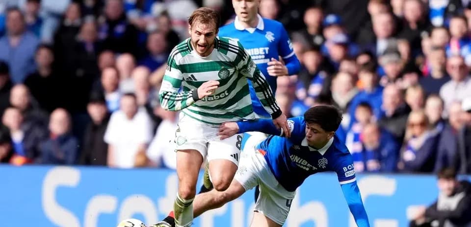 Celtic player evading tackle from Rangers opponent